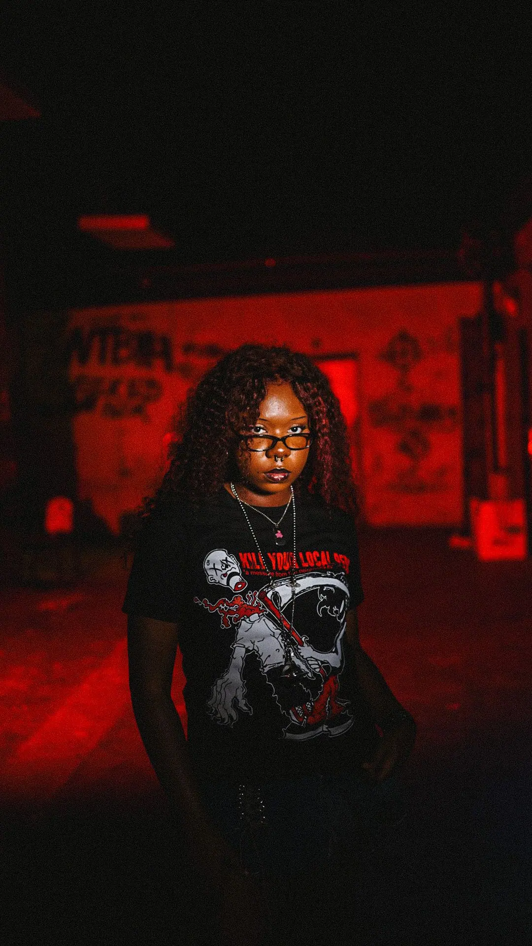 Model in the red room wearing the Kill Your Local tee